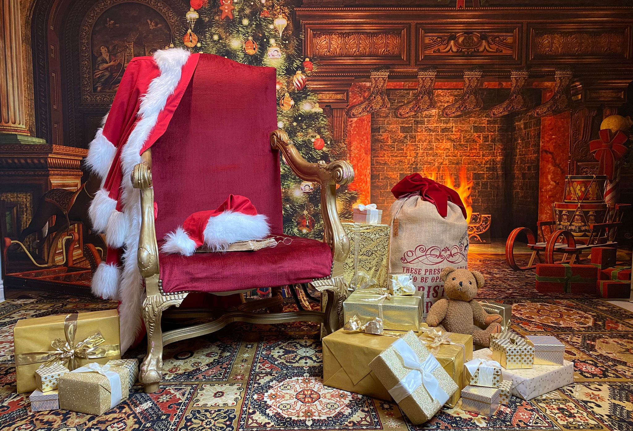 Leerer Thronsessel von Weihnachtsmann Claudius im Kaminzimmer mit Geschenkpaketen